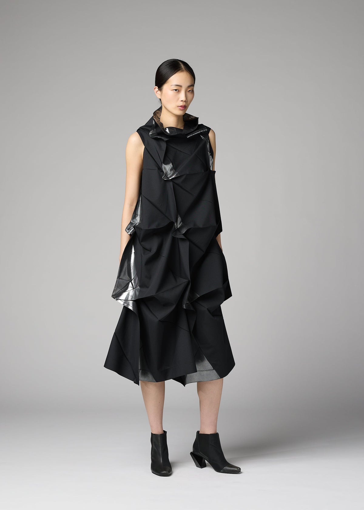 A model wears the 132 5. ISSEY MIYAKE No.1-1 no-1-1-dress-black-x-silver.