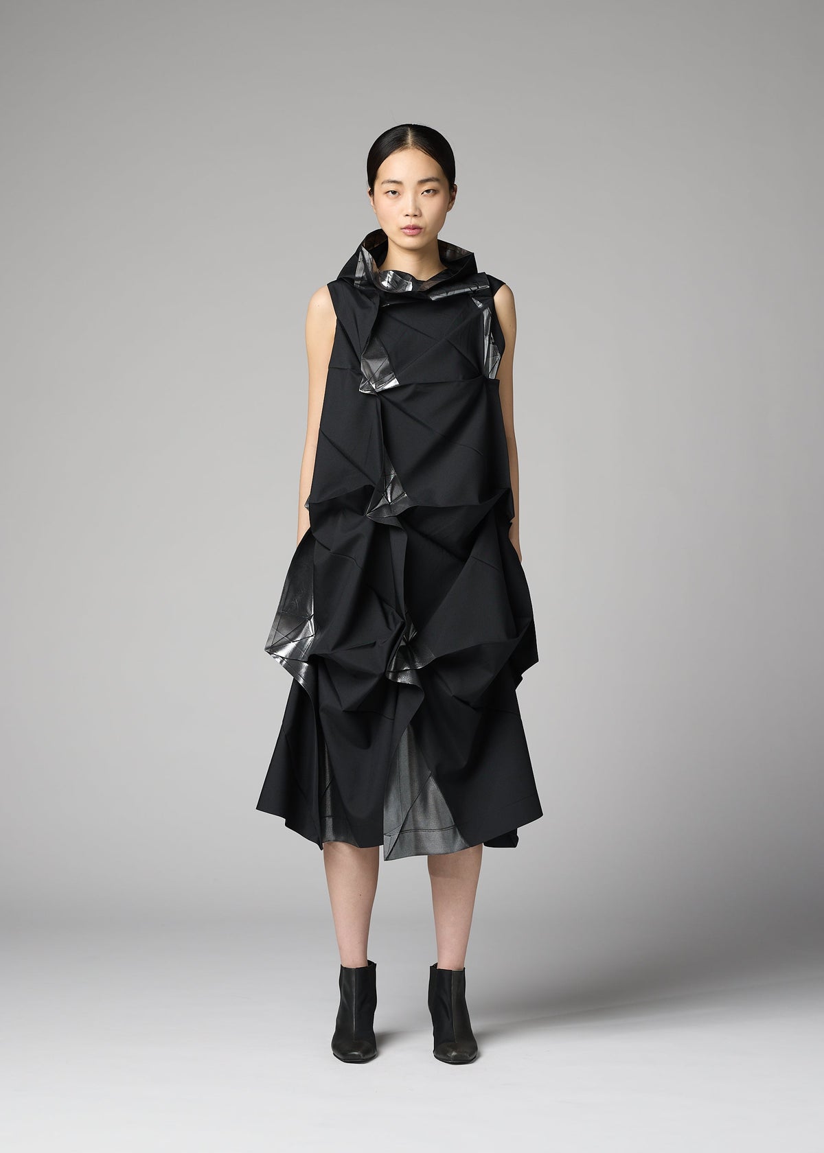 A model wears the 132 5. ISSEY MIYAKE No.1-1 no-1-1-dress-black-x-silver.