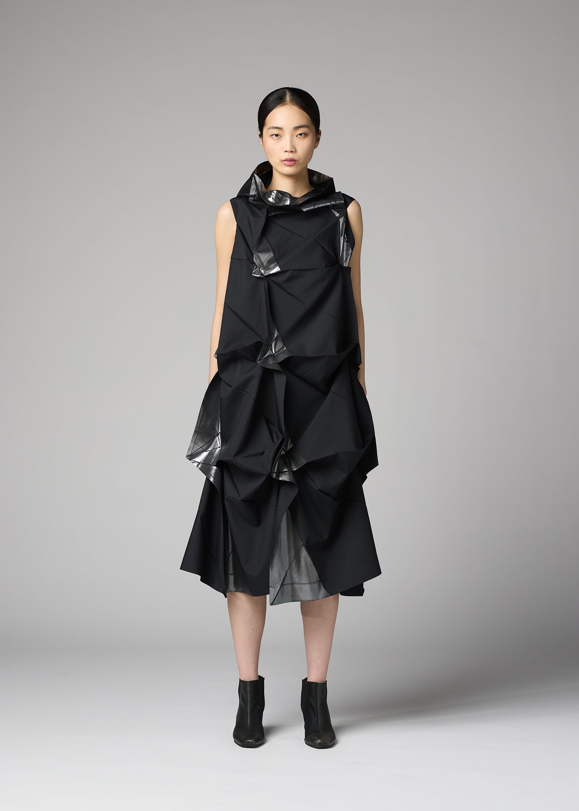 A model wears the 132 5. ISSEY MIYAKE No.1-1 no-1-1-dress-black-x-silver.