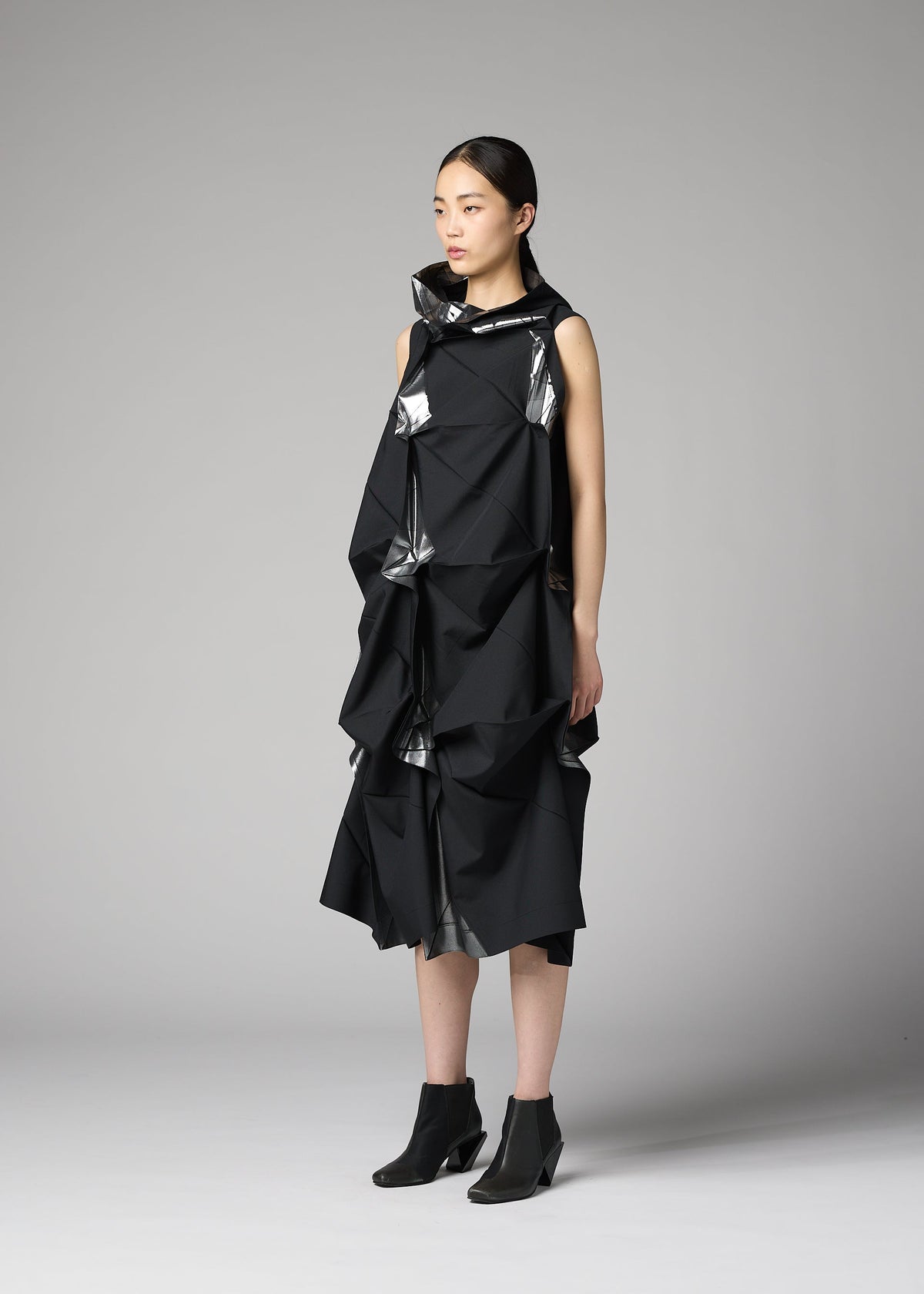 A model wears the 132 5. ISSEY MIYAKE No.1-1 no-1-1-dress-black-x-silver.