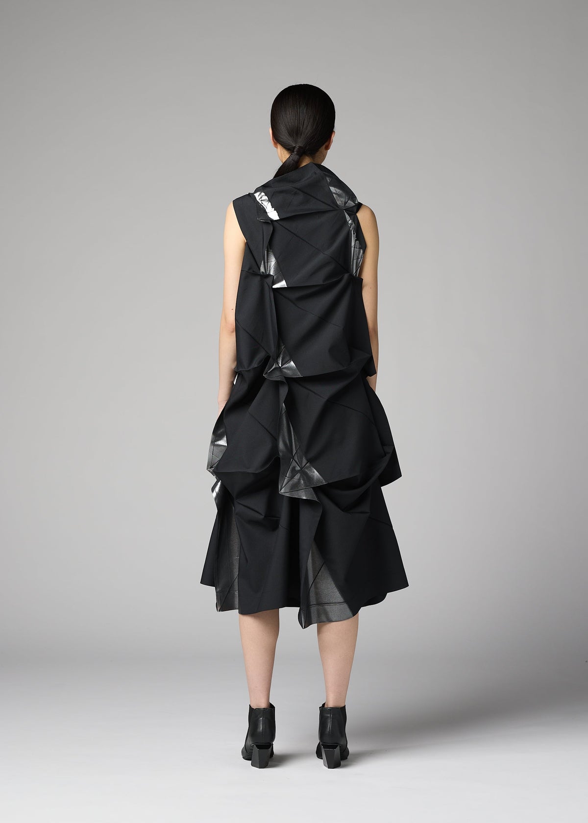 A model wears the 132 5. ISSEY MIYAKE No.1-1 no-1-1-dress-black-x-silver.