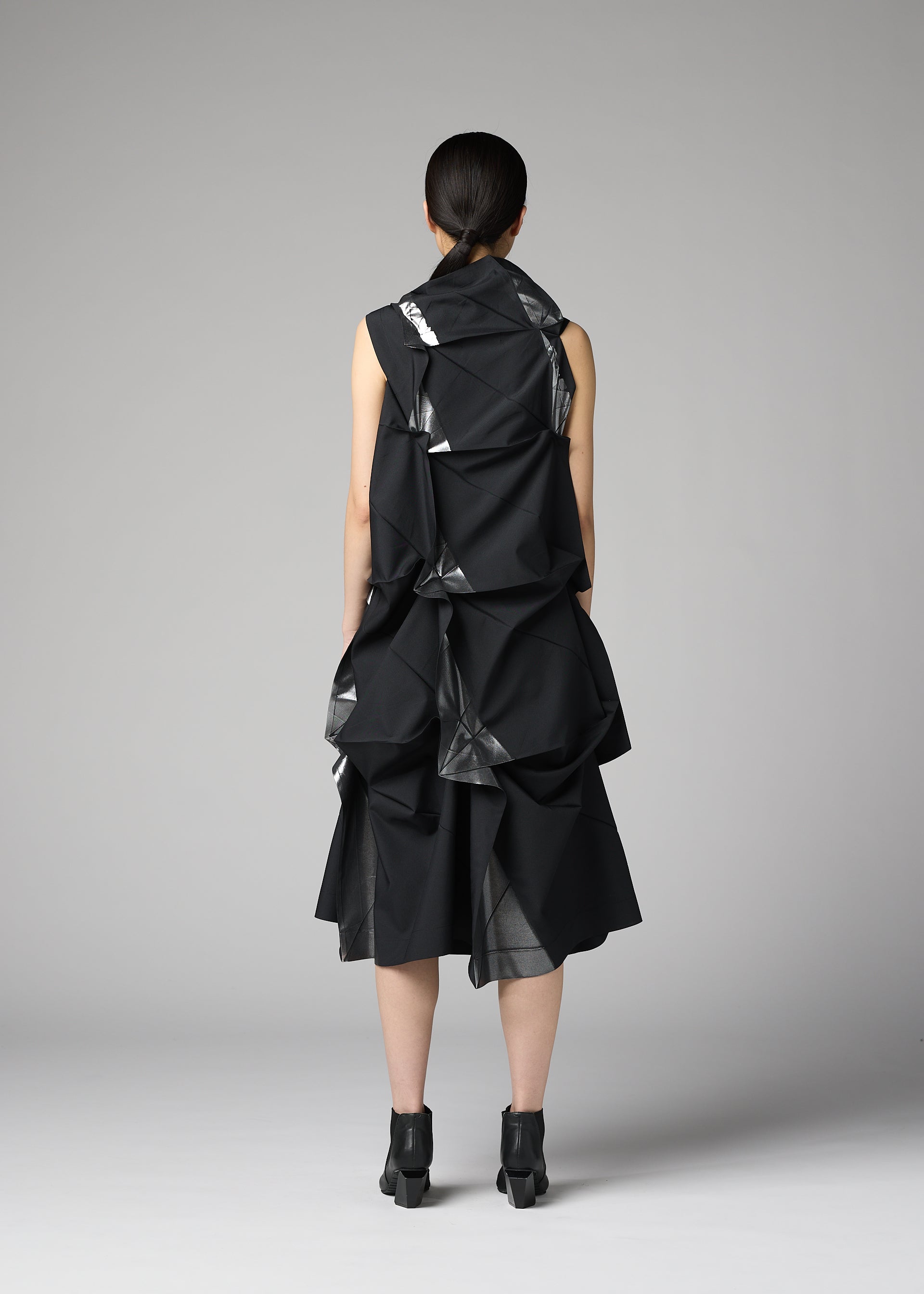 A model wears the 132 5. ISSEY MIYAKE No.1-1 no-1-1-dress-black-x-silver.