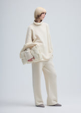 A model wears the ISSEY MIYAKE SQUARE CUSHION bag.