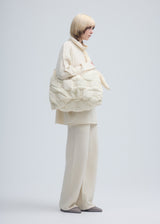 A model wears the ISSEY MIYAKE SQUARE CUSHION bag.