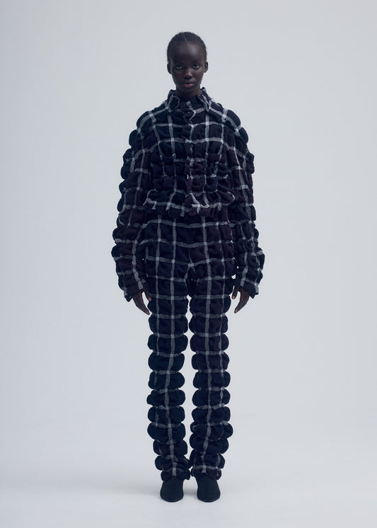 A model wears the ISSEY MIYAKE PRISM CHECK jacket.