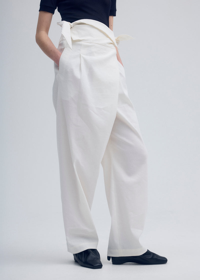 A model wears the ISSEY MIYAKE  ENCLOTHE PANTS trousers