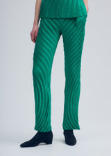 A model wears the ISSEY MIYAKE NUANCE PLEATS SOLID trousers.