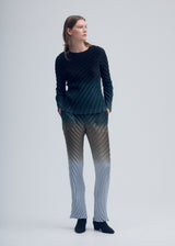 A model wears the ISSEY MIYAKE NUANCE PLEATS shirt.