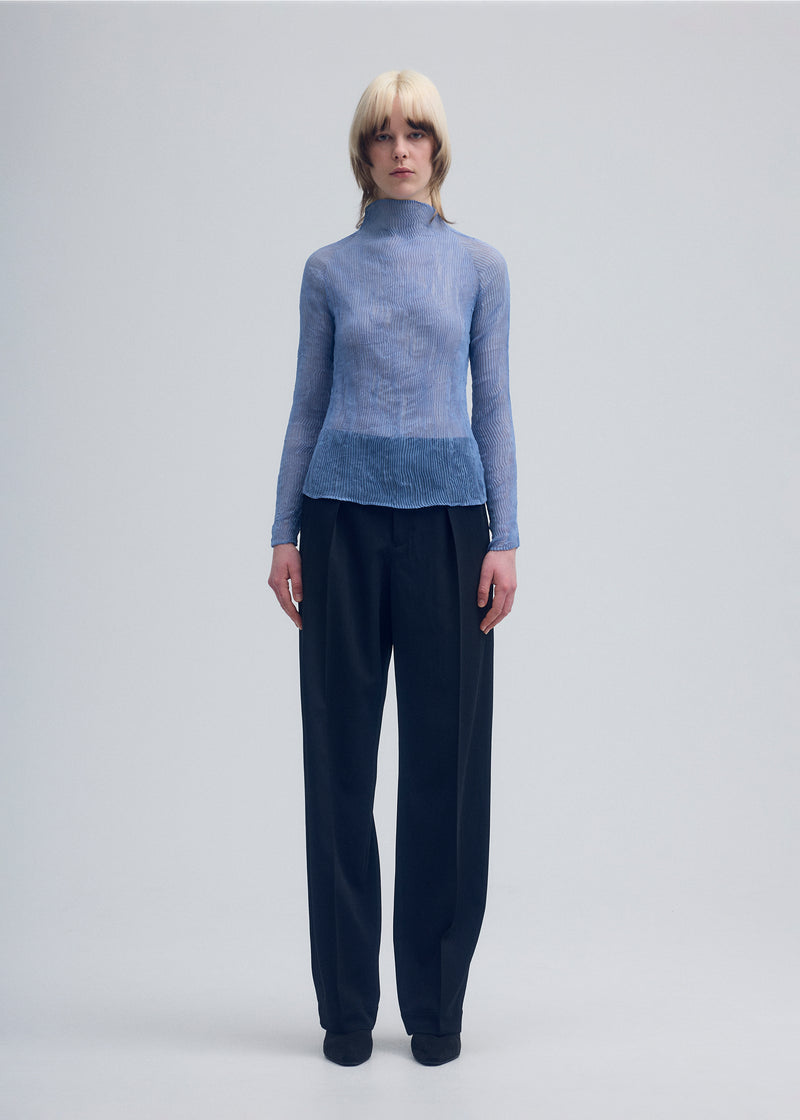 A model wears the ISSEY MIYAKE  CHIFFON TWIST 1 top