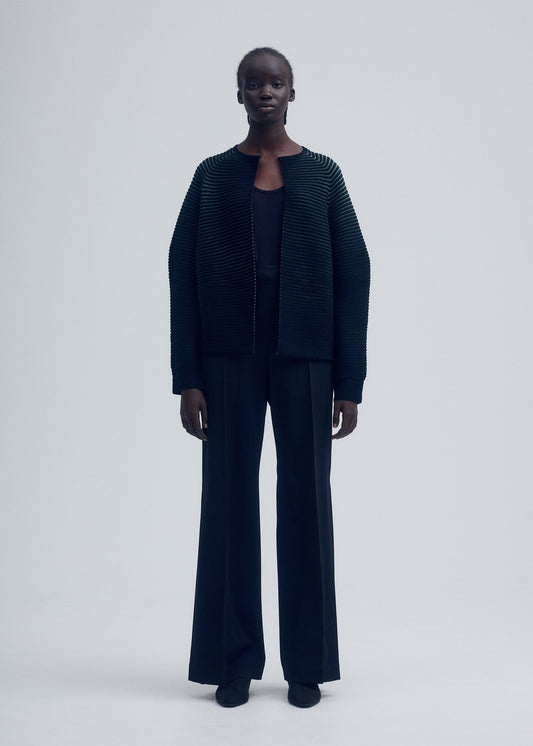 A model wears the ISSEY MIYAKE CIRCLE KNIT cardigan.