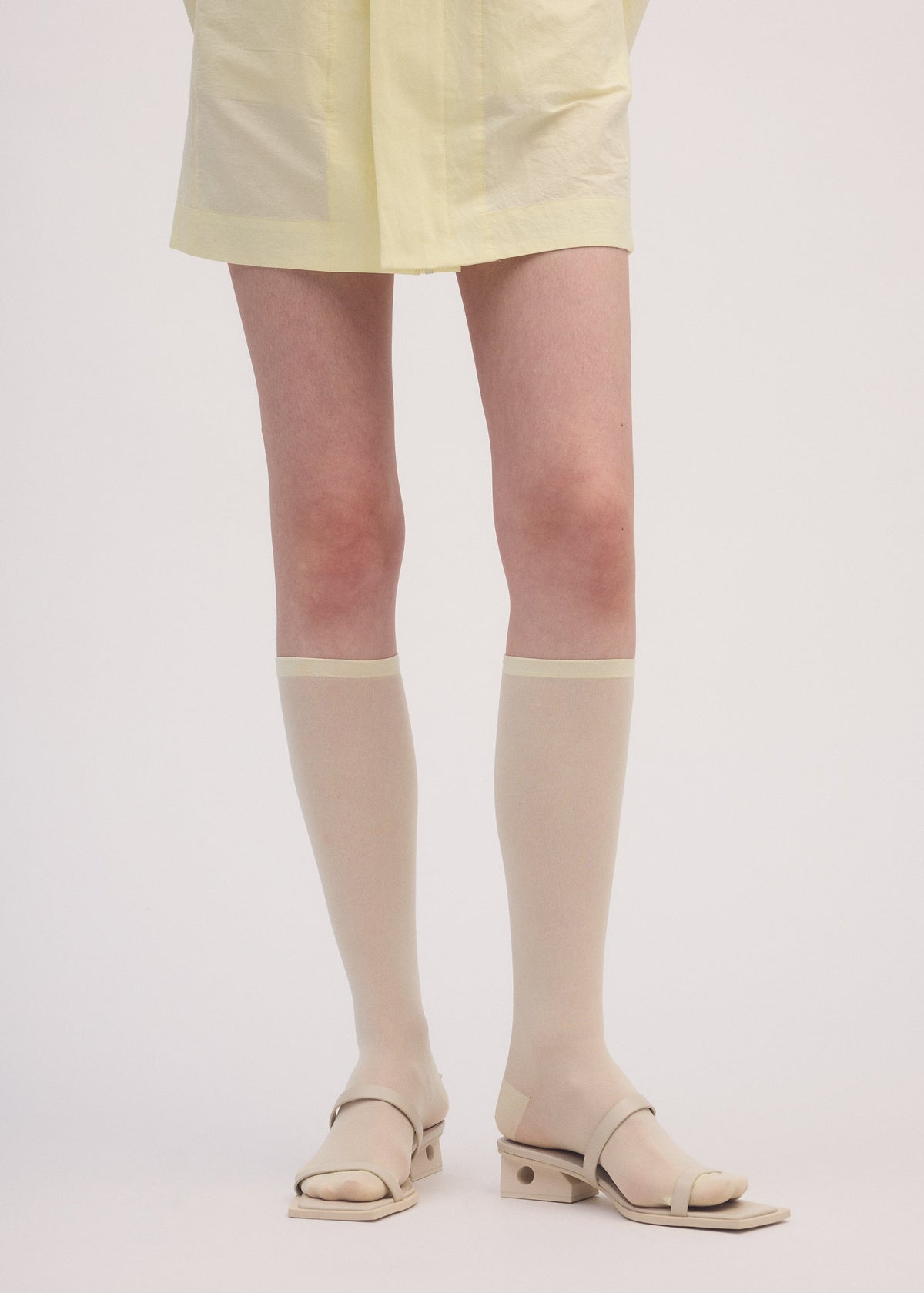 A model wears the ISSEY MIYAKE SHEER SOCKS socks.