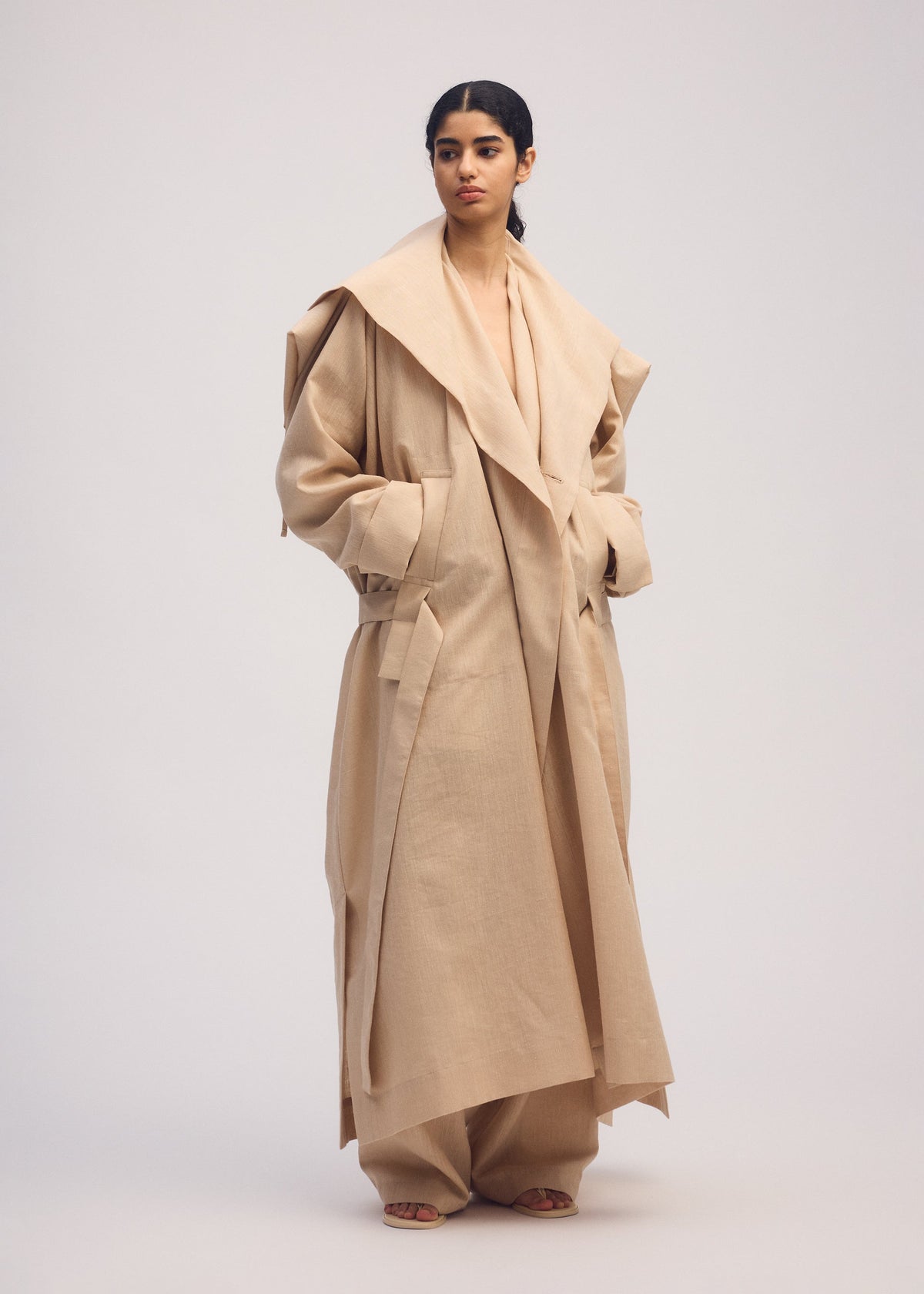 A model wears the ISSEY MIYAKE EASE AND EASED coat.