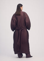 A model wears the ISSEY MIYAKE WAVERING PLEATS coat.