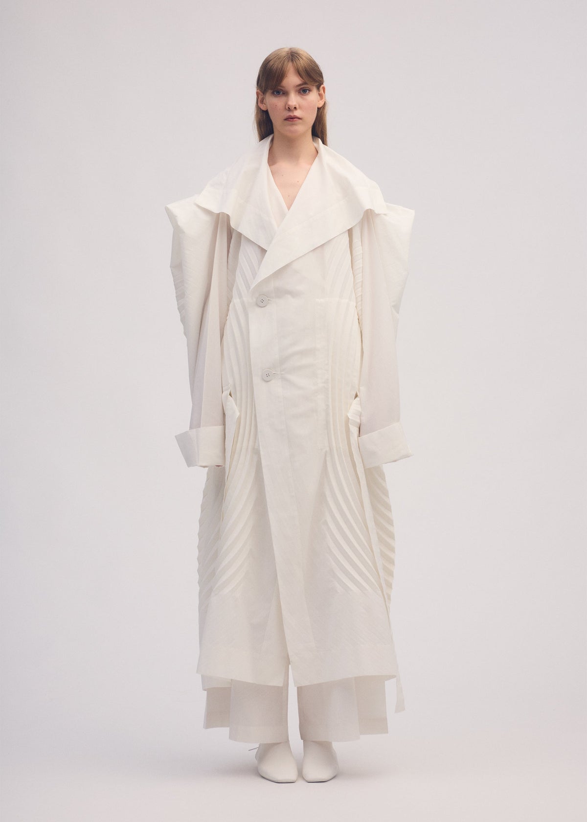 A model wears the ISSEY MIYAKE FLOW coat.