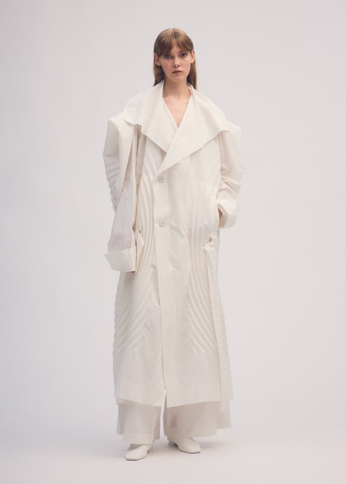 A model wears the ISSEY MIYAKE FLOW coat.