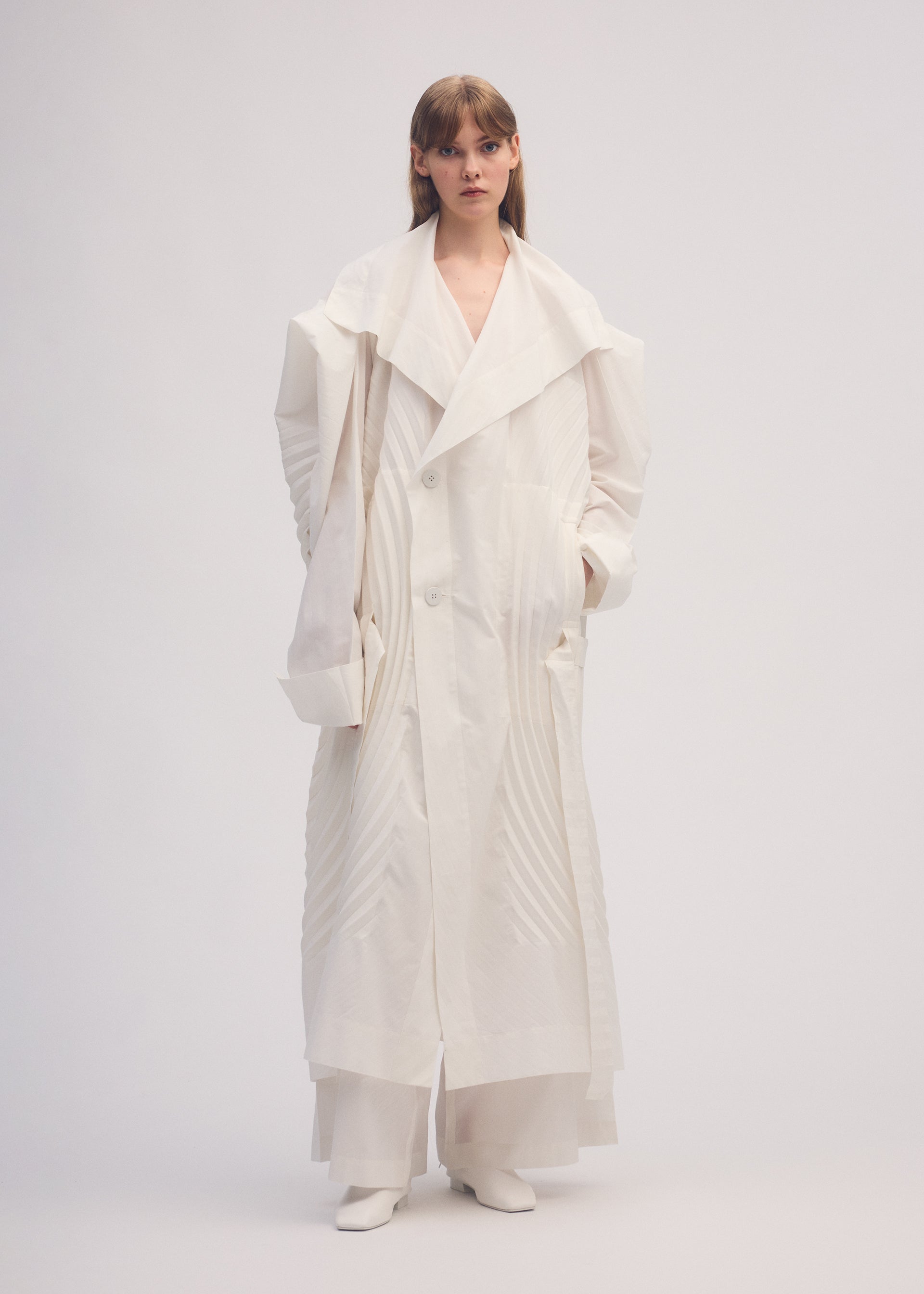 A model wears the ISSEY MIYAKE FLOW coat.