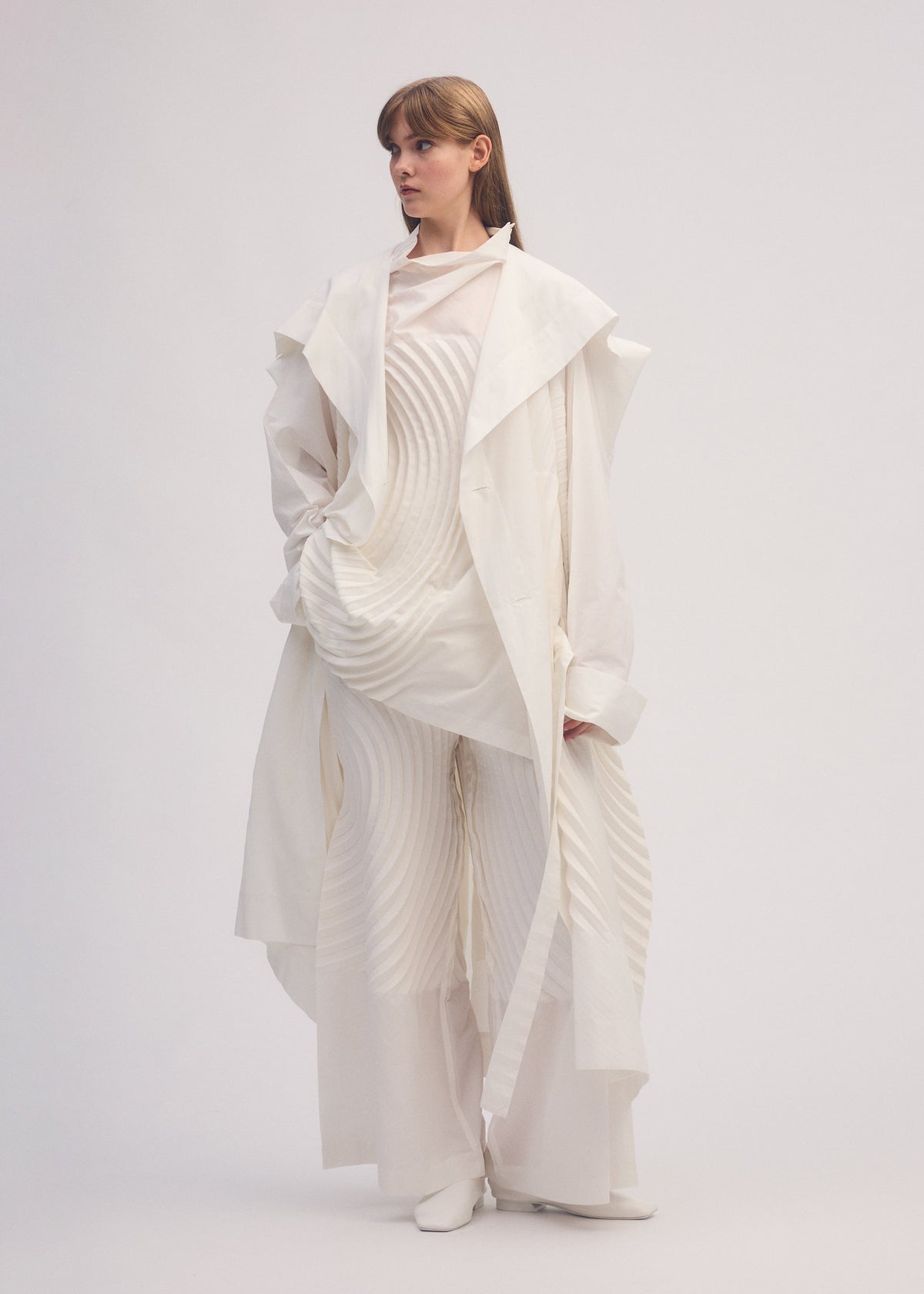 A model wears the ISSEY MIYAKE FLOW coat.