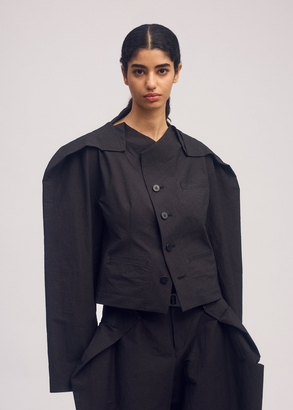 A model wears the ISSEY MIYAKE FOLD TO FORM jacket.