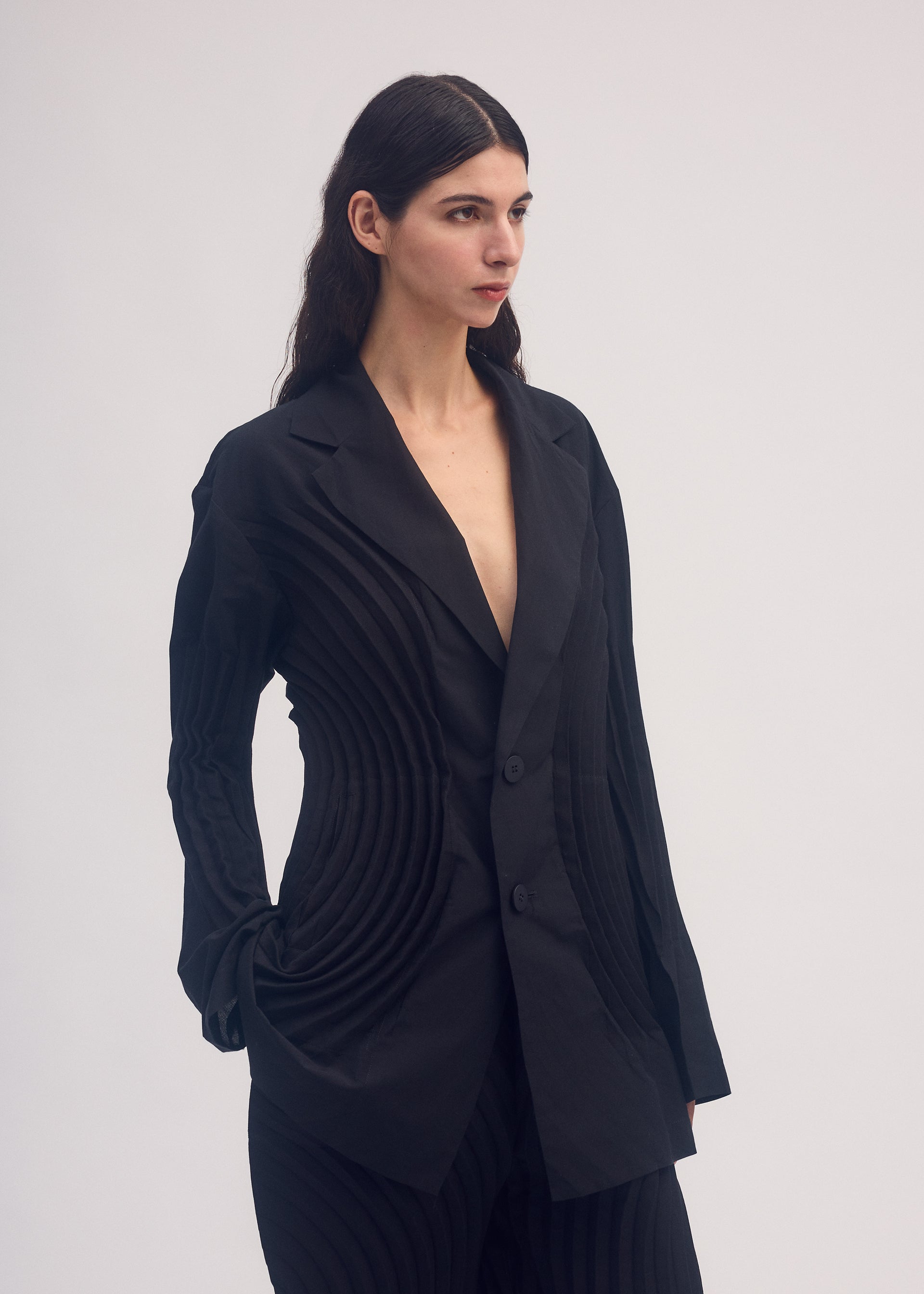 A model wears the ISSEY MIYAKE FLOW jacket.