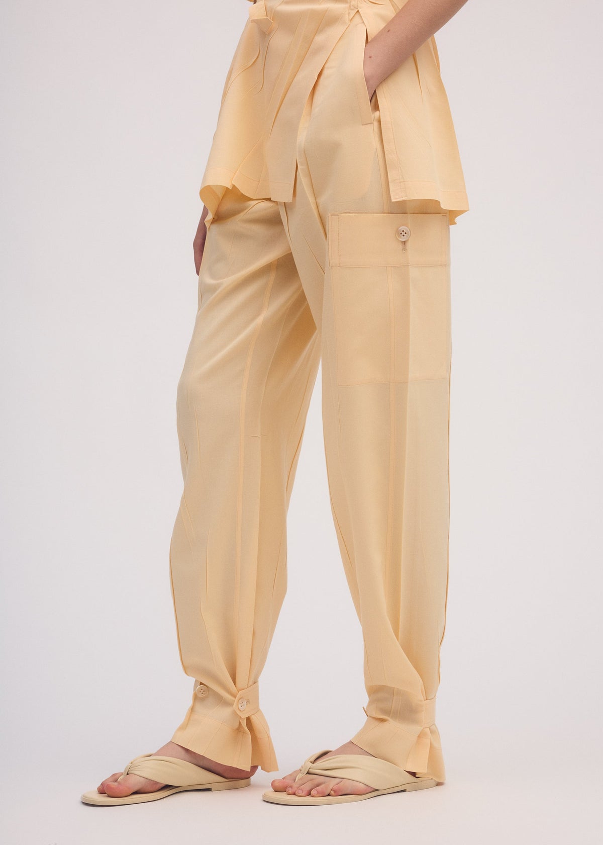 A model wears the ISSEY MIYAKE PRESSED FORM trousers.