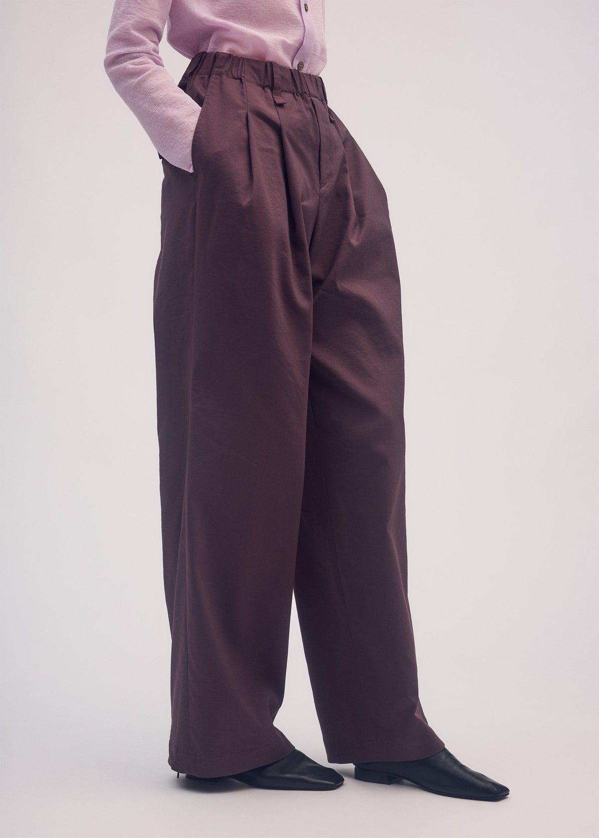 A model wears the ISSEY MIYAKE PERSONALITY PANTS trousers.