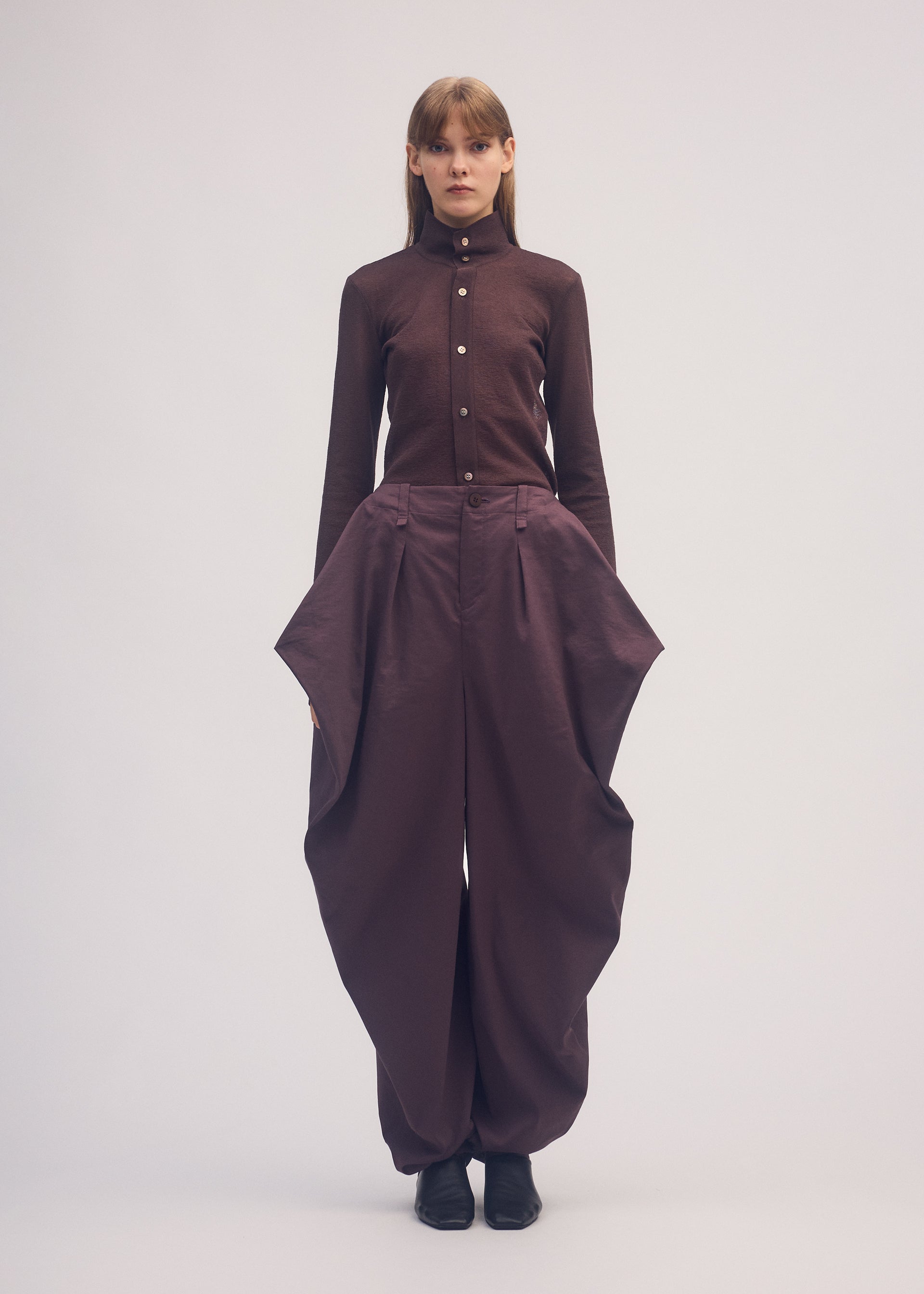 A model wears the ISSEY MIYAKE PERSONALITY PANTS trousers.