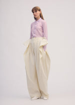 A model wears the ISSEY MIYAKE PERSONALITY PANTS trousers.