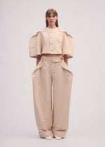 A model wears the ISSEY MIYAKE FOLD TO FORM trousers.