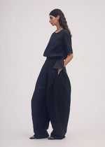 A model wears the ISSEY MIYAKE HEMPEN trousers.