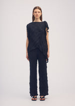 A model wears the ISSEY MIYAKE WRINKLED AND TWISTED trousers.