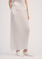 A model wears the ISSEY MIYAKE SHADOW STUDY PLEATS SOLID skirt.