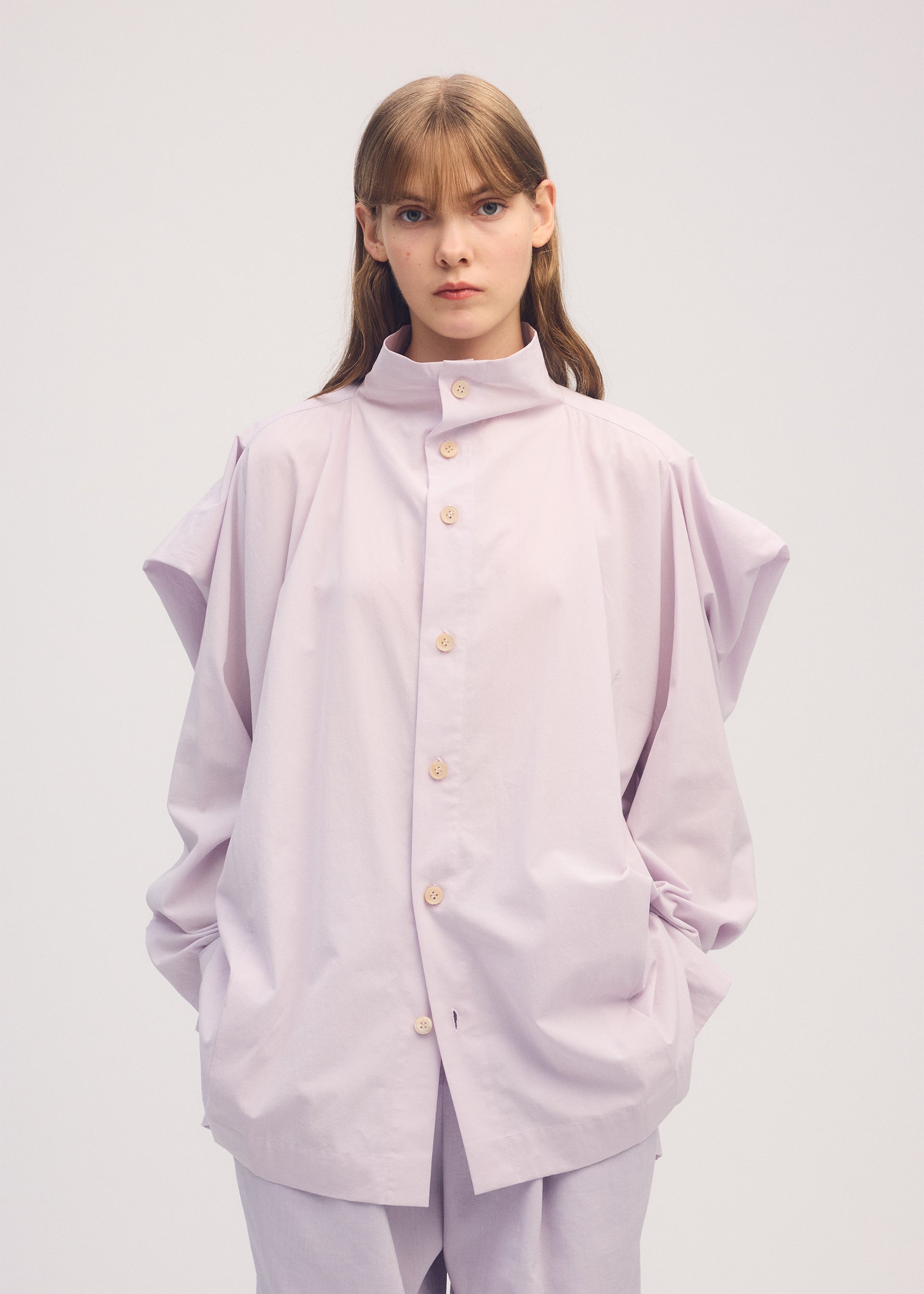 A model wears the ISSEY MIYAKE COTTON VOILE SHIRT shirt.