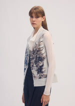 A model wears the ISSEY MIYAKE PRESSED FLORA PLEATS TOP shirt.