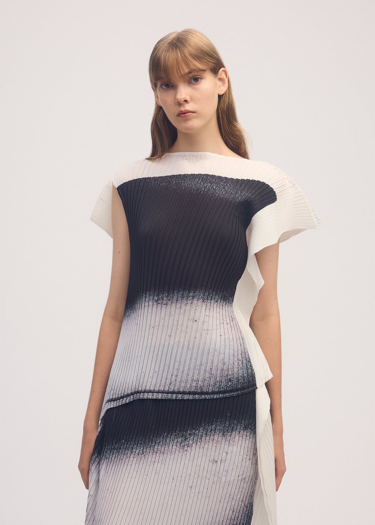 A model wears the ISSEY MIYAKE SHADOW STUDY PLEATS shirt.