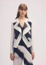 A model wears the ISSEY MIYAKE SHADOW STUDY PLEATS cardigan.