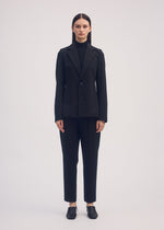 A model wears the ISSEY MIYAKE SIMPLE ENSEMBLE jacket.