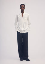 A model wears the ISSEY MIYAKE SIMPLE ENSEMBLE trousers.