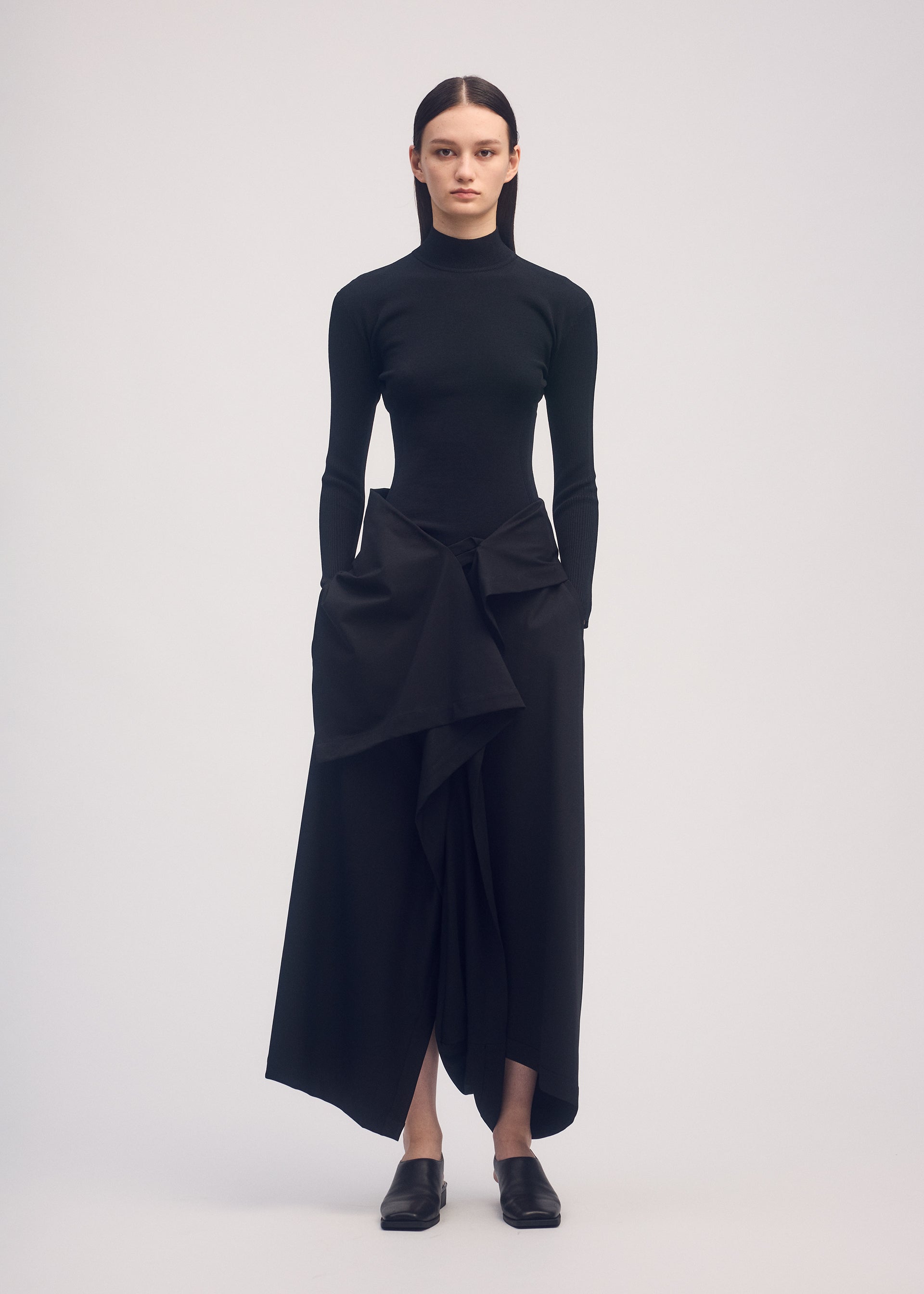 A model wears the ISSEY MIYAKE SIMPLE ENSEMBLE trousers.