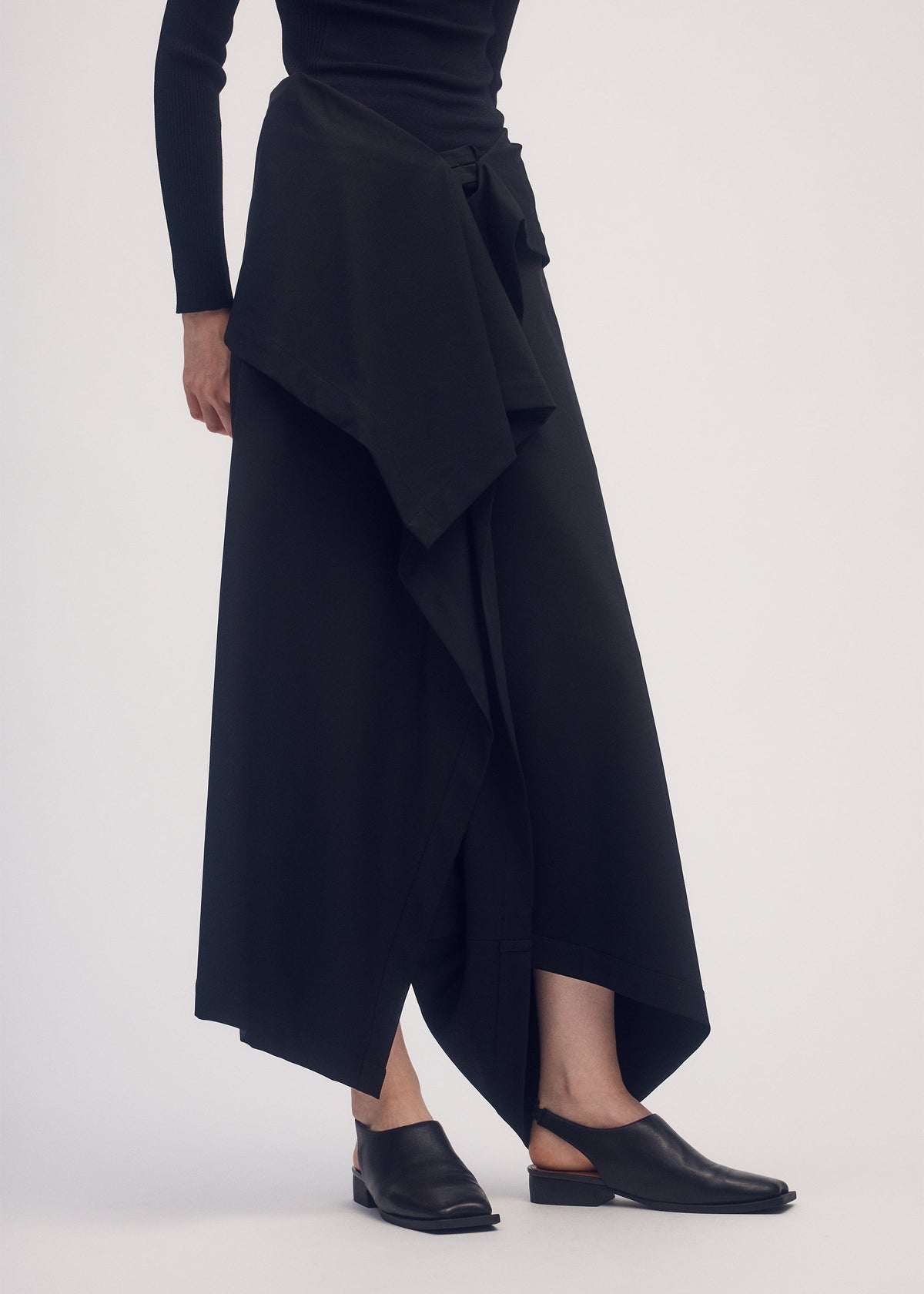 A model wears the ISSEY MIYAKE SIMPLE ENSEMBLE trousers.