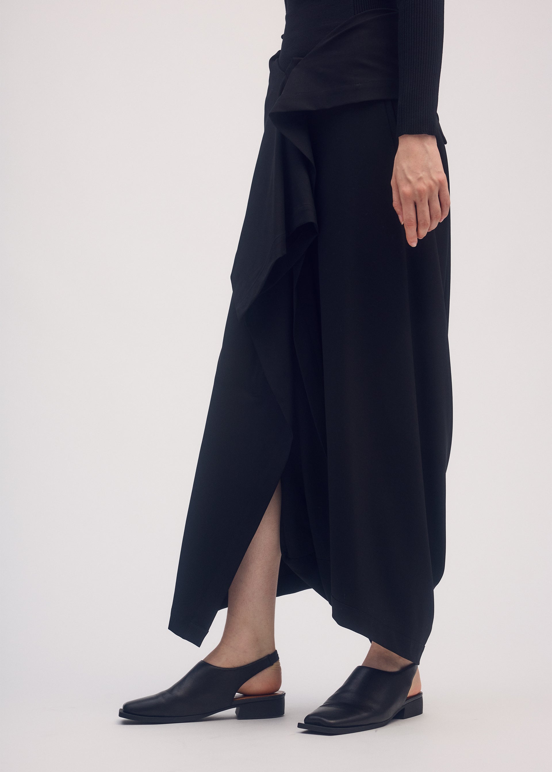 A model wears the ISSEY MIYAKE SIMPLE ENSEMBLE trousers.