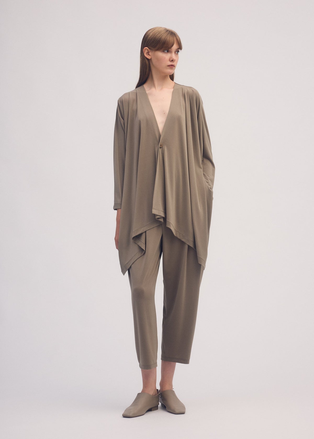 A model wears the ISSEY MIYAKE DRAPE JERSEY 56 cardigan.
