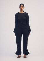 A model wears the ISSEY MIYAKE STREAM trousers.