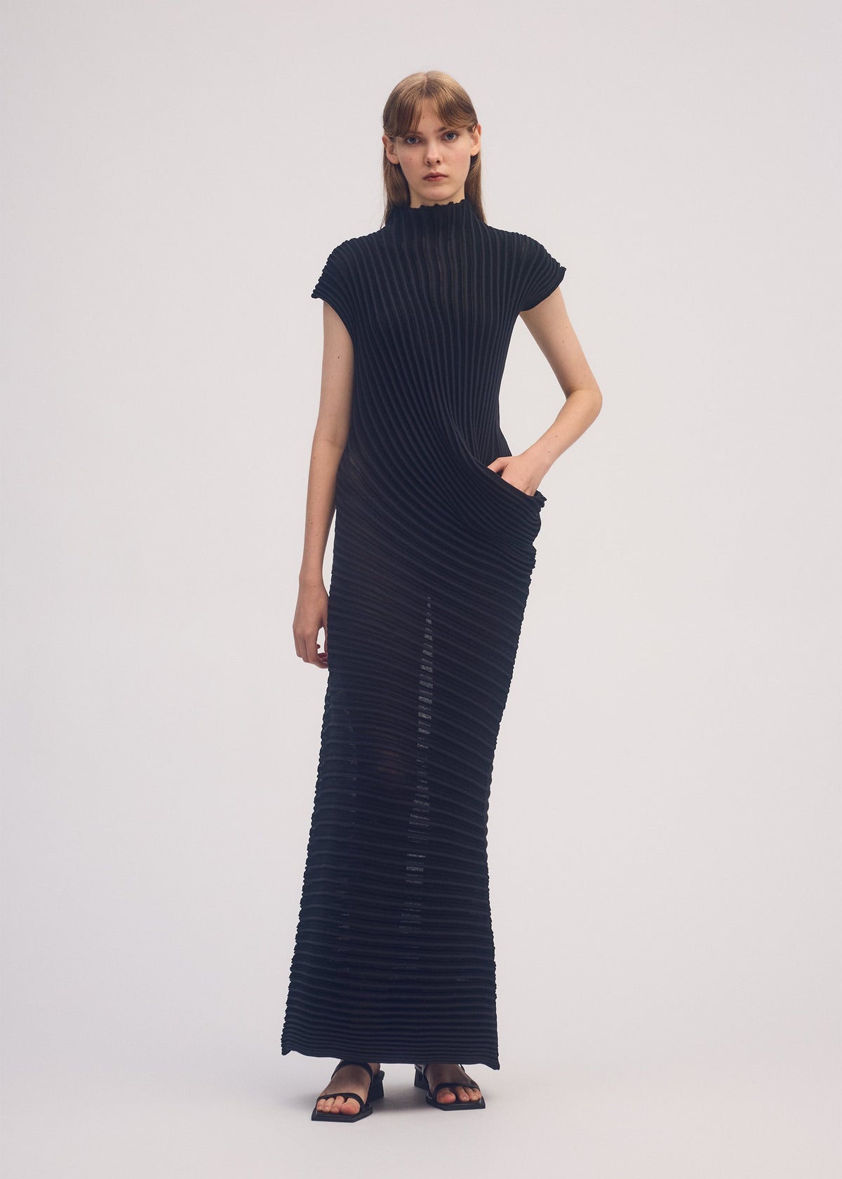 A model wears the ISSEY MIYAKE STREAM dress.