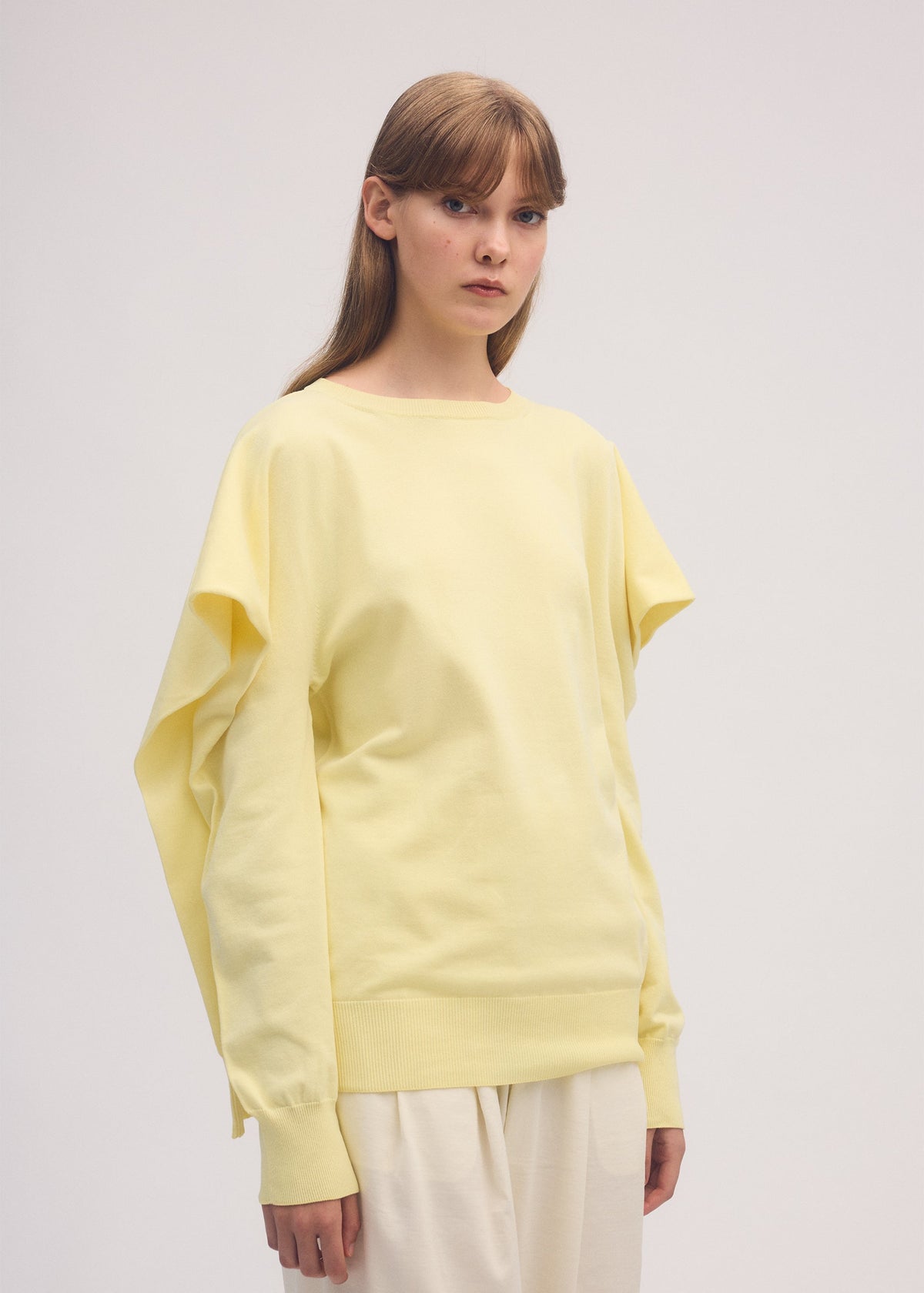 A model wears the ISSEY MIYAKE FOUR SLEEVED top.