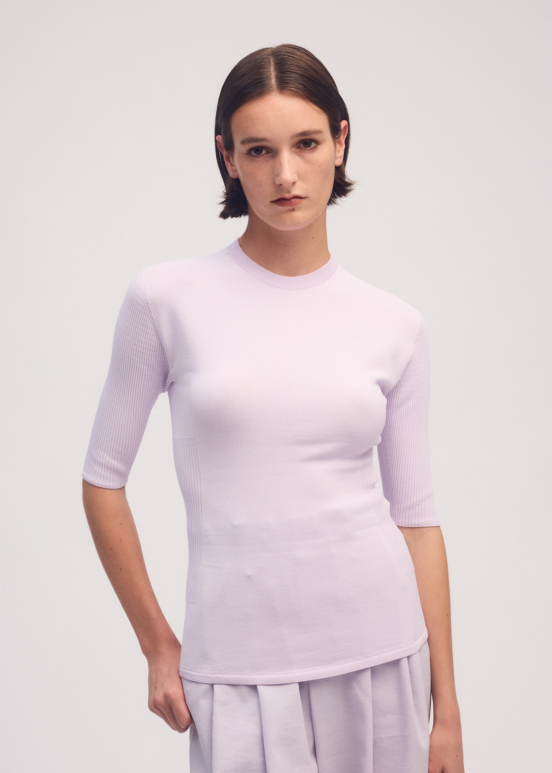 A model wears the ISSEY MIYAKE MELLOW STRETCH top.