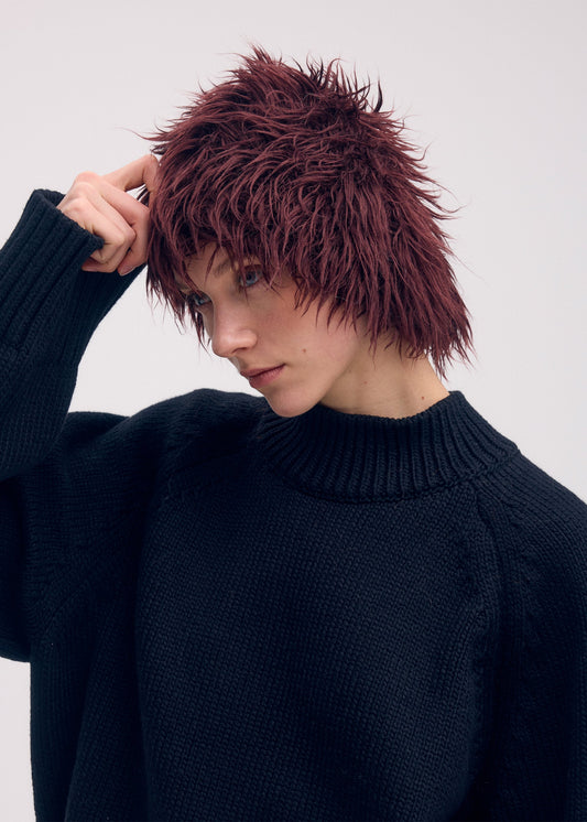 A model wears the ISSEY MIYAKE ODD BEANIE hat.