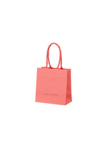 A product shot of the ISSEY MIYAKE THIS IS A PAPER BAG bag in coral (23).