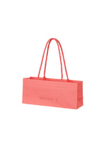 A product shot of the ISSEY MIYAKE THIS IS A PAPER BAG bag in coral (23).