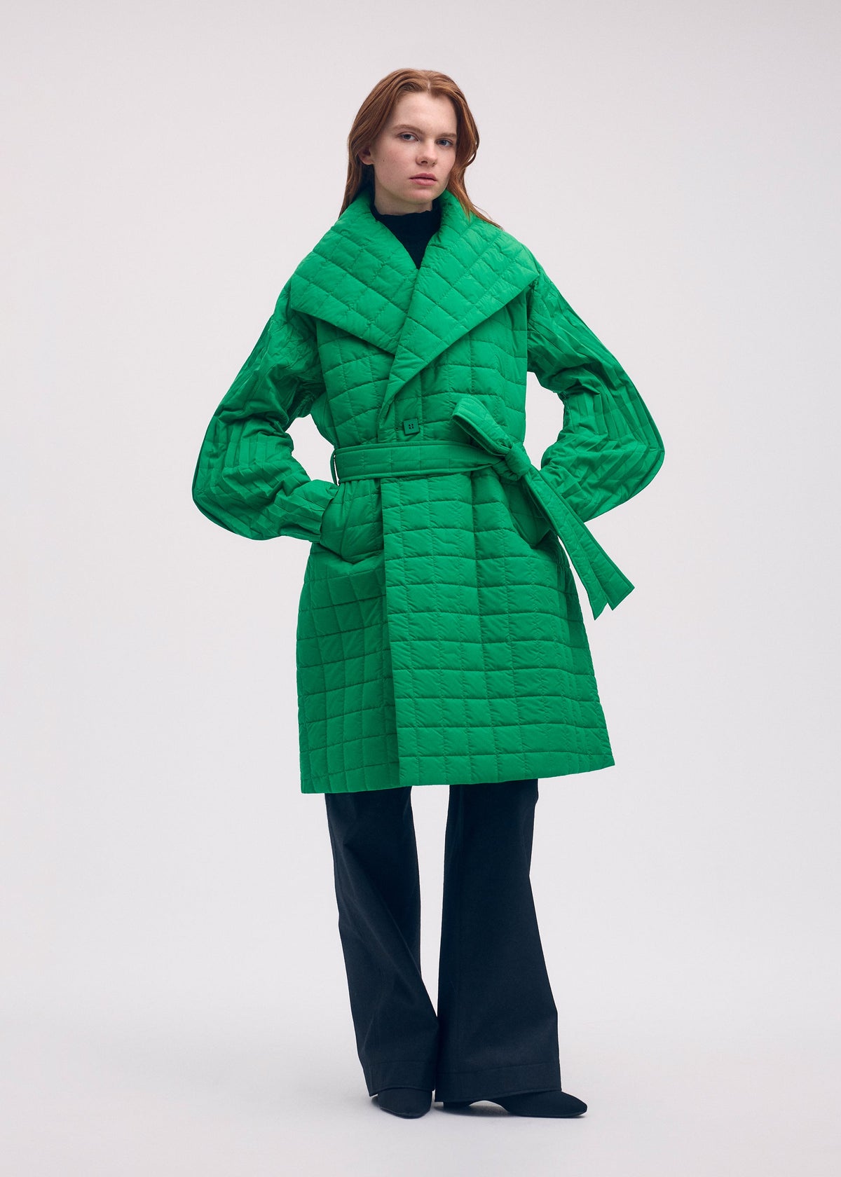 A model wears the ISSEY MIYAKE PLEATED GRID coat.