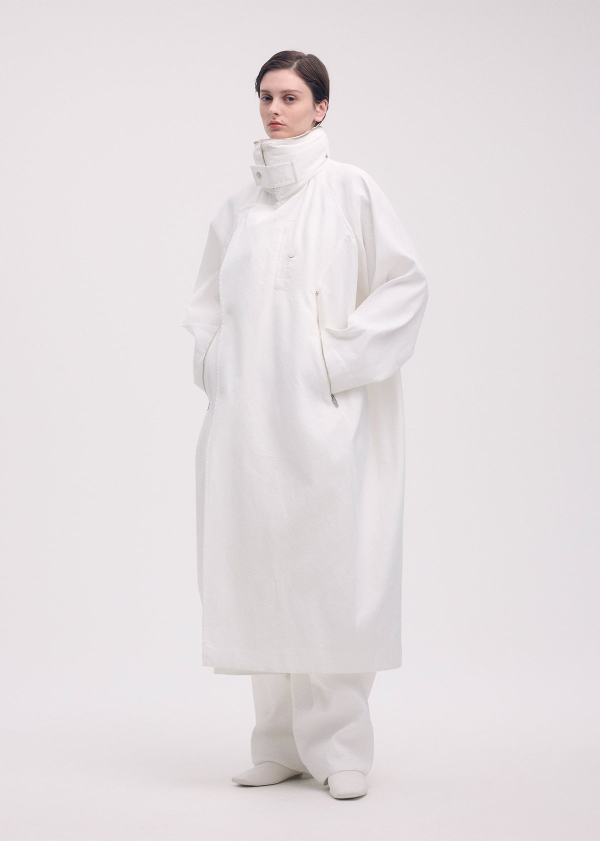 A model wears the ISSEY MIYAKE PEEKABOO coat.